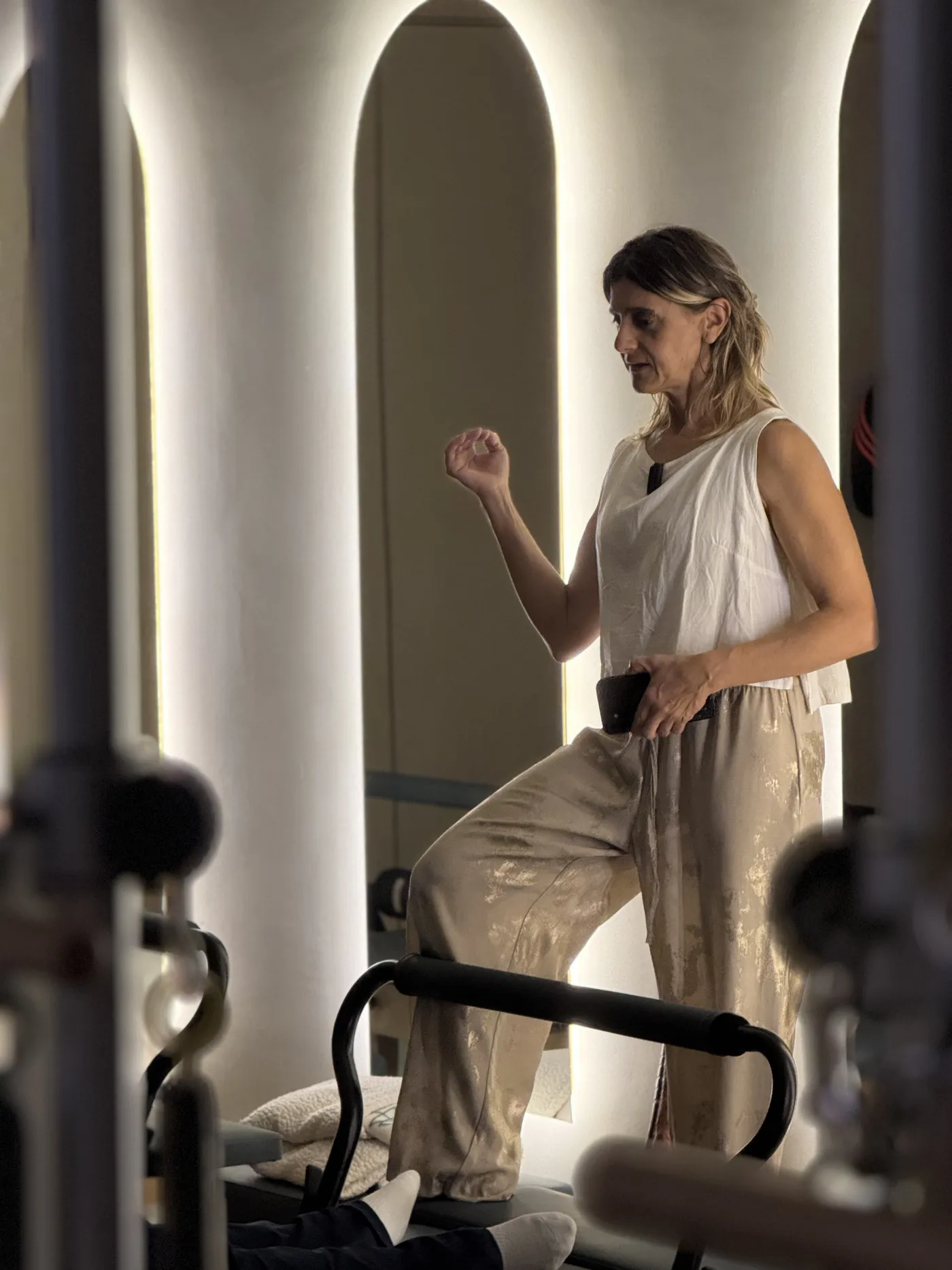 La instructora caminando entre los arcos iluminados del estudio