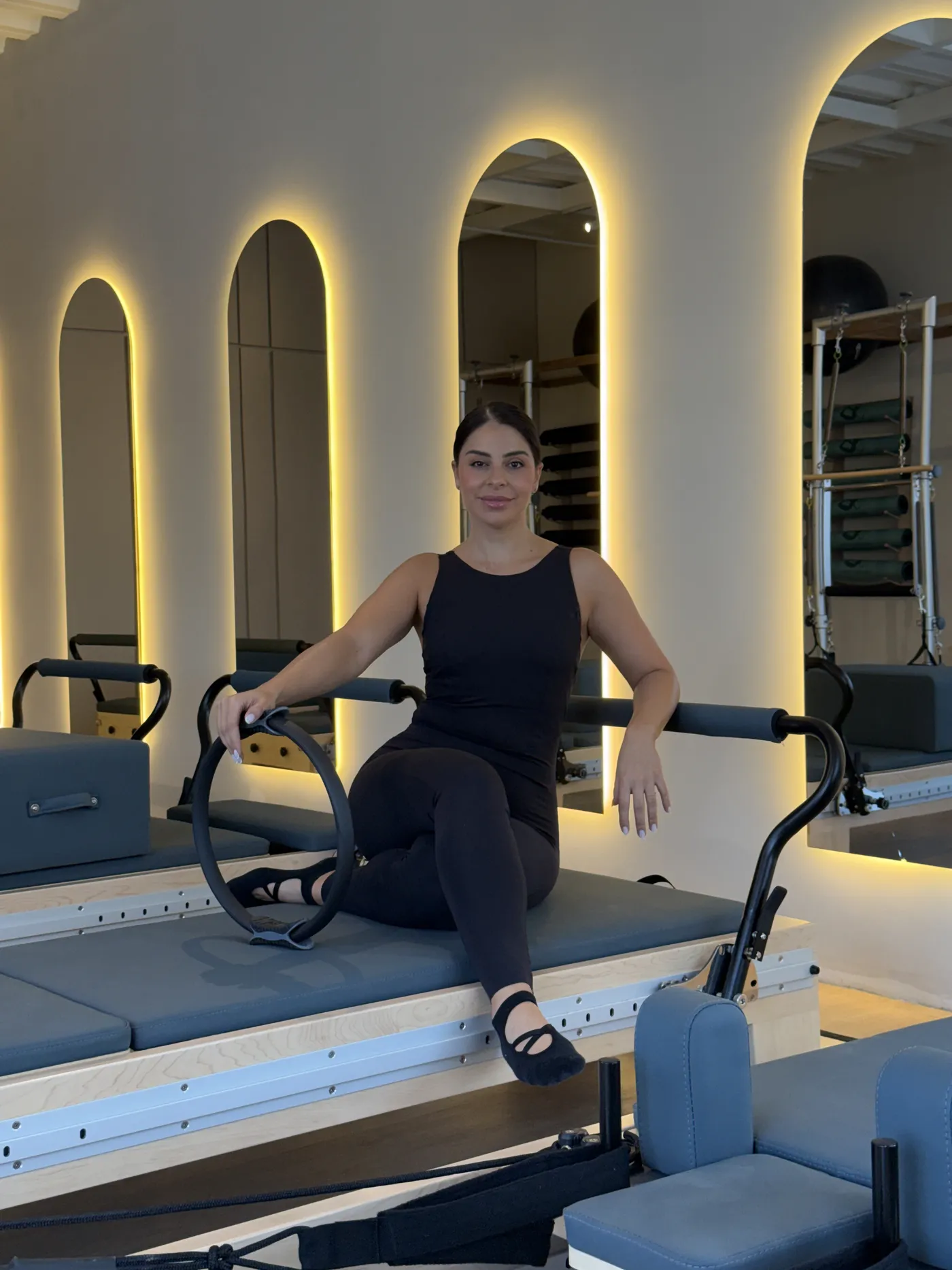 La encargada del estudio, con un aro de pilates en las manos, sonriendo a cámara